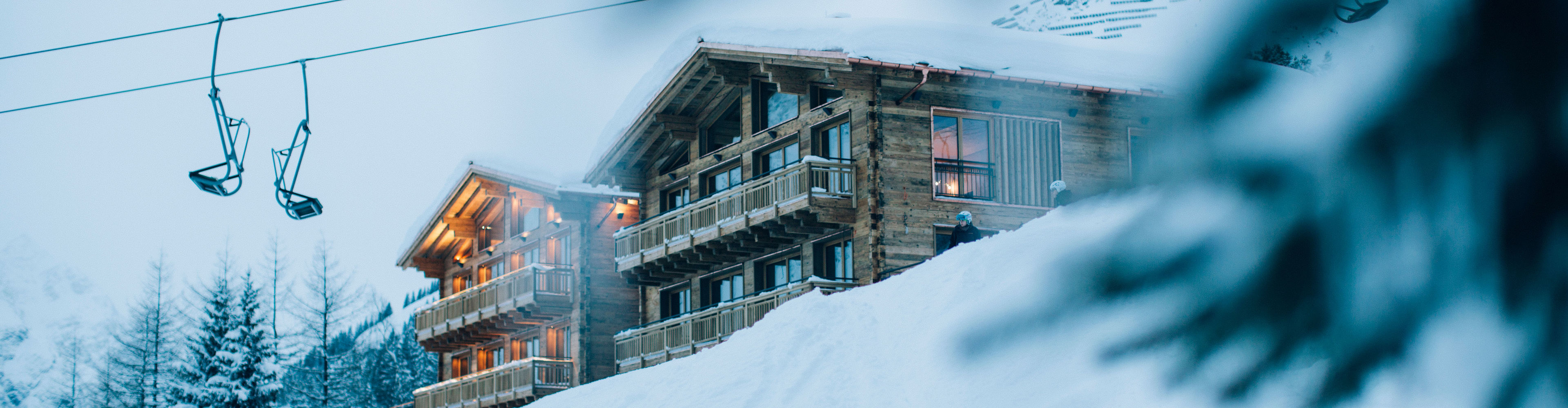 Blick auf beleuchtete Holzhäuser inmitten der Skiregion