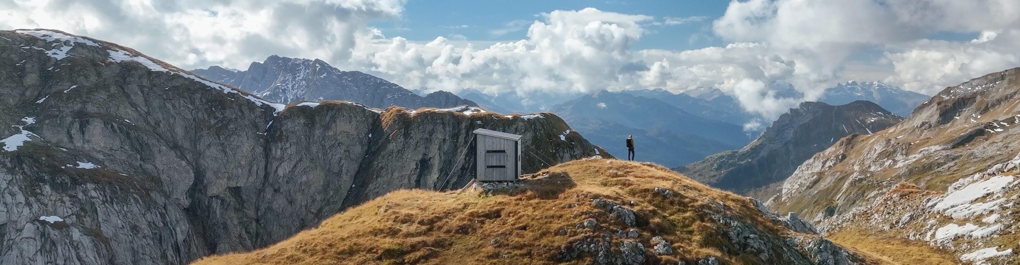 Biwak Hütte inmitten der Berge bei Sonnenschein