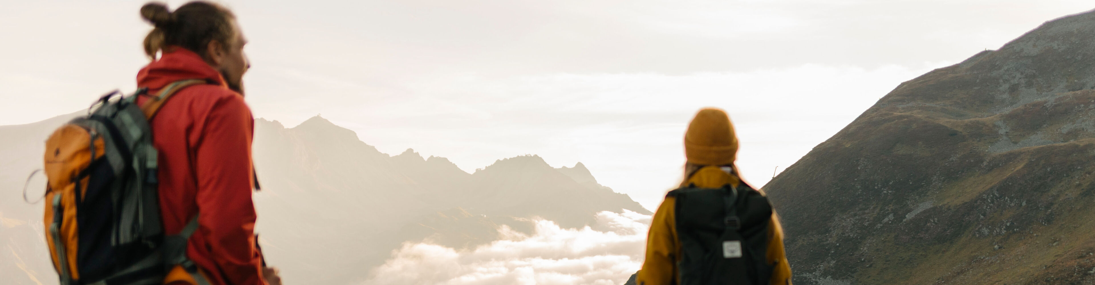 Zwei Wanderer blicken auf das umliegende Bergpanorama