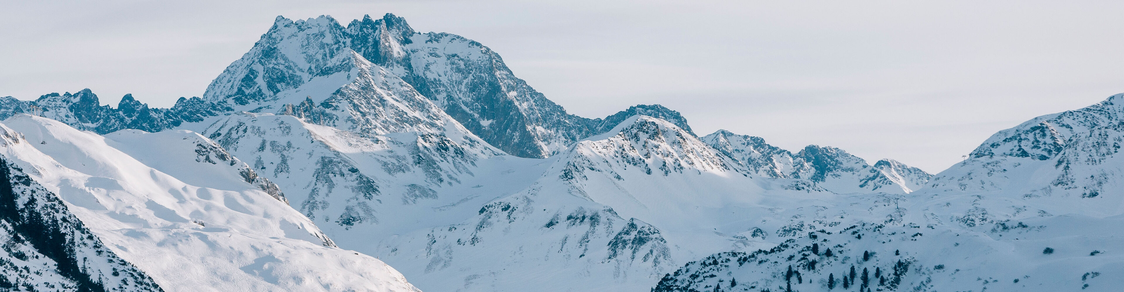 Blick auf die schneebedeckten Bergkulissen, die in den ersten Sonnenstrahlen erleuchten
