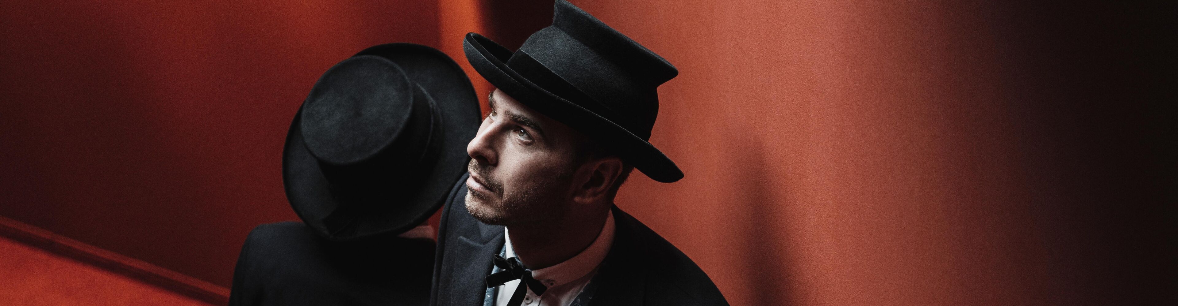 Zwei Männer in Walser Tracht mit schwarzen Hüten, Kniebundhosen, Lederschuhen mit Silberschnalle