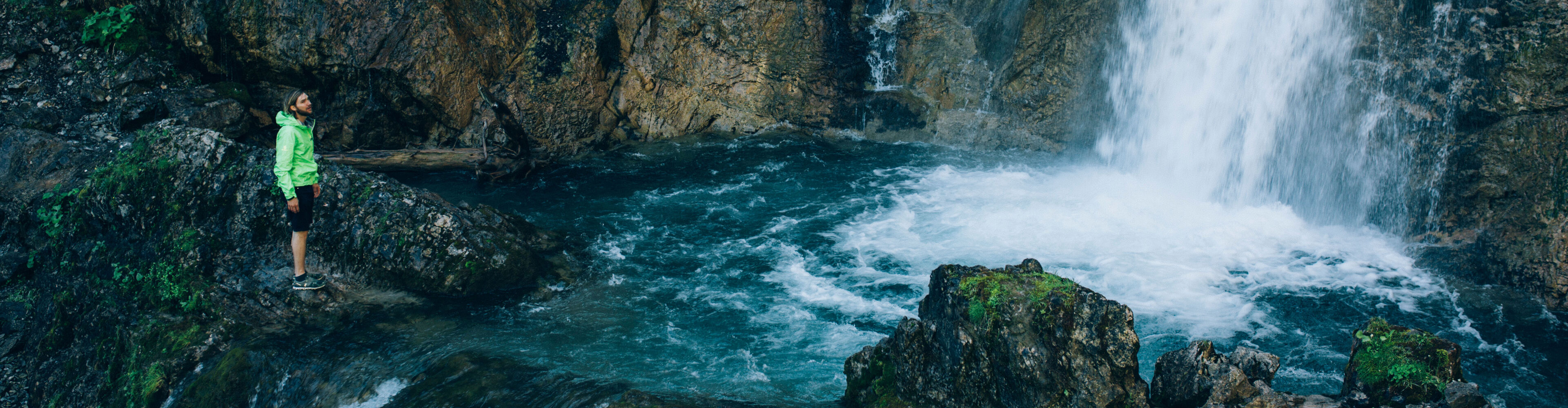 der dunkelblaue Wasserfall plätschert in ein Becken im Felsen