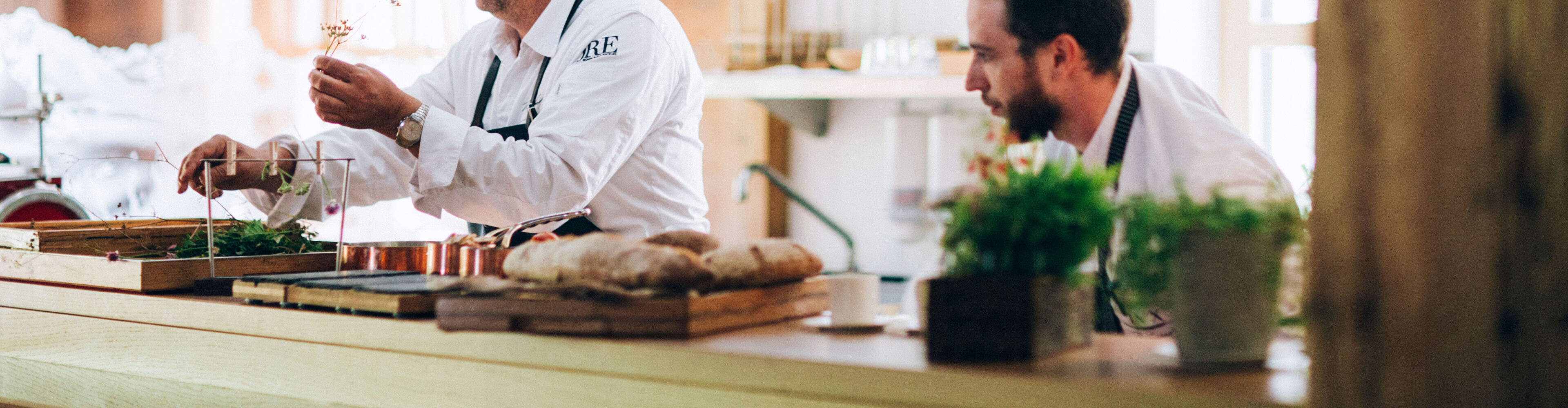 Köche stehen am Küchenpass und bereiten die Gerichte für den Service vor