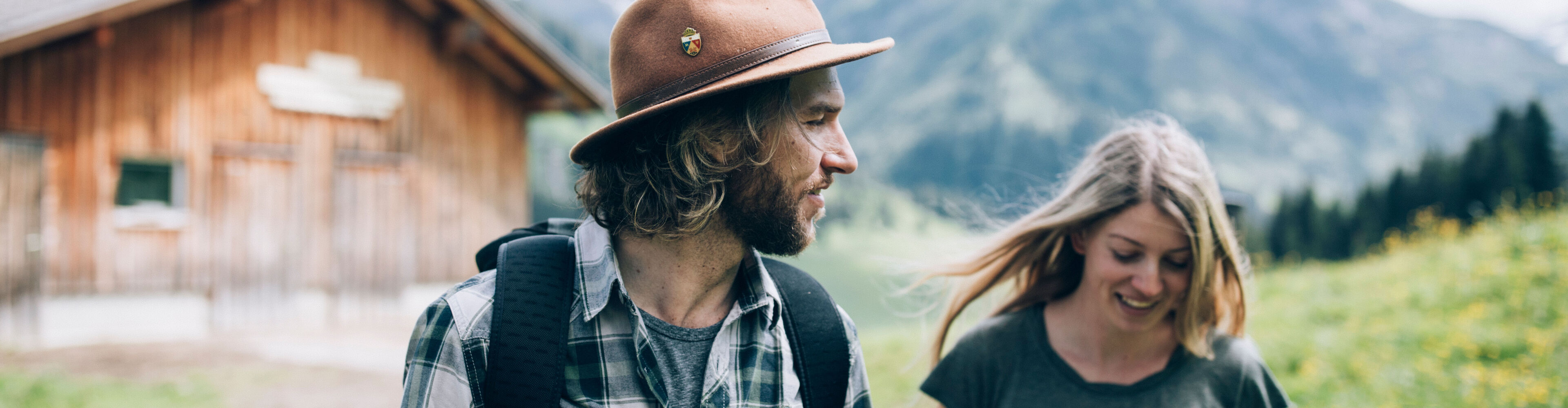 ein junges Paar wandert über den Forstweg in Bürstegg, im Hintergrund sieht man das herrliche Bergpanorama