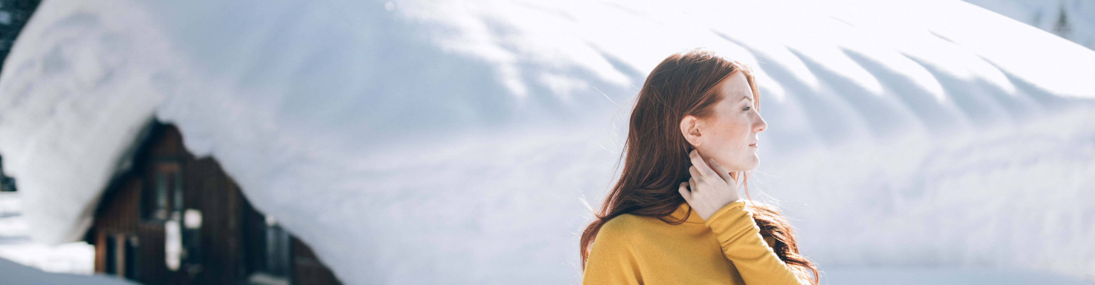 eine Frau bleibt beim Winterwandern stehen und genießt die ruhigen Momente in der winterlichen Landschaft von Lech Zürs
