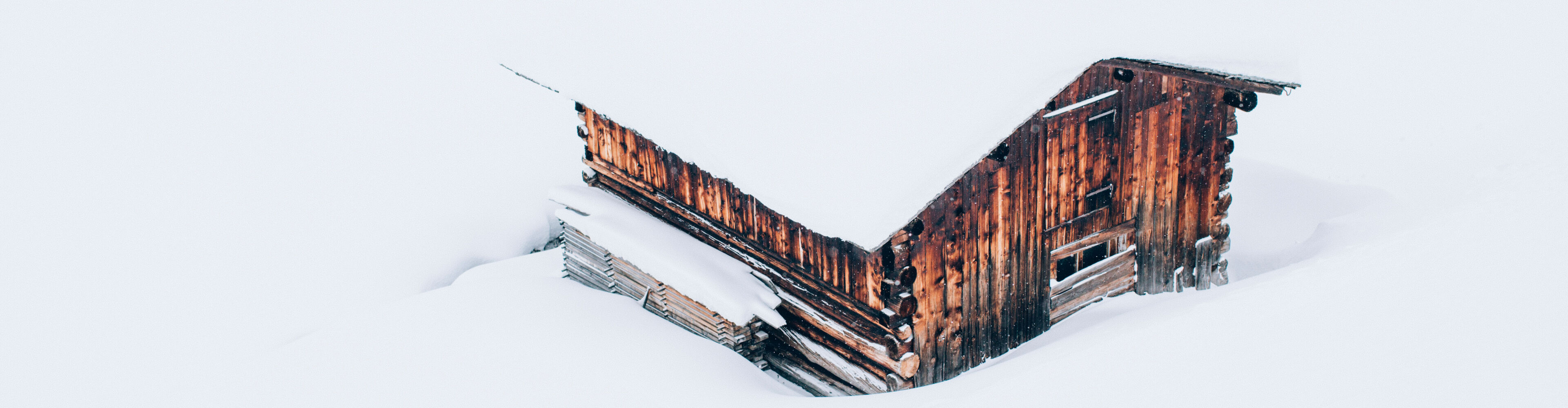 ein uriges Haus steht schneebedeckt inmitten der Schneelandschaft