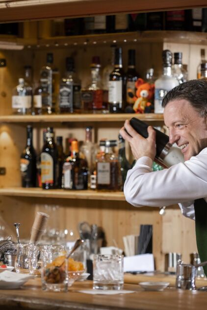 Ein Barkeeper hinter der Theke beim Cocktail shake Ein Barkeeper hinter der Theke beim Cocktail shake