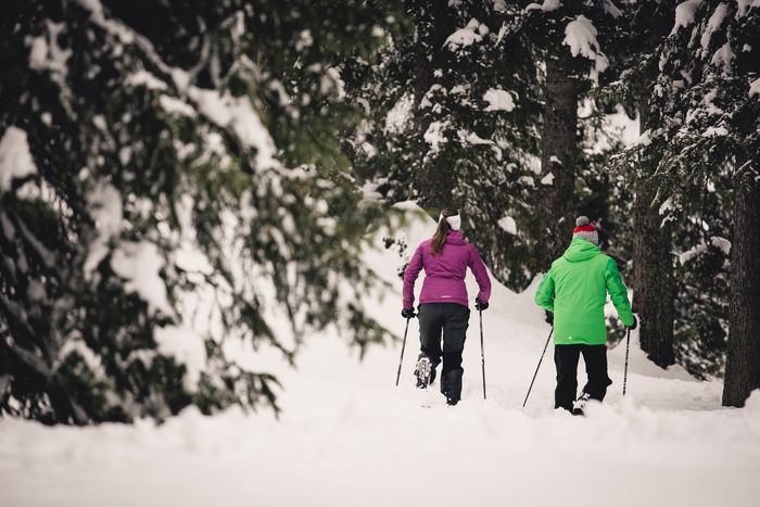 zwei Personen wandern mit ihren Schneeschuhen durch die Winterlandschaft von Lech Zürs am Arlberg