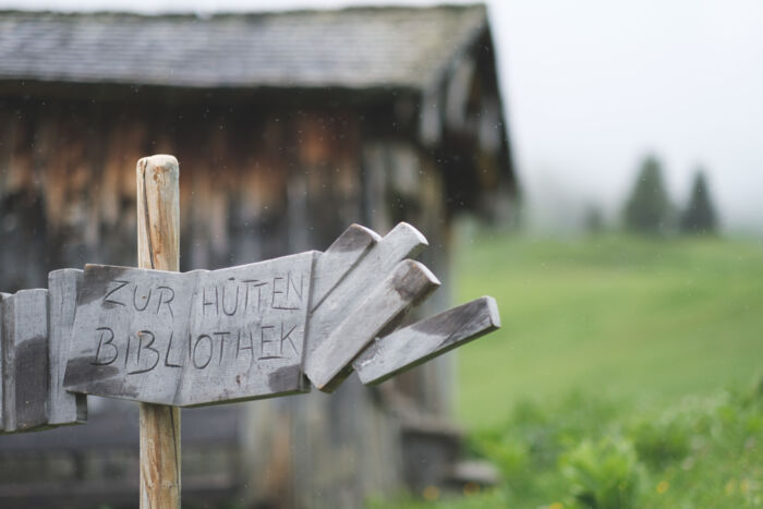 Schild welches zur Hüttenbibliothek im Hintergrund verweist