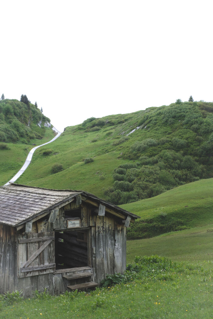 Hüttenbibliothek mir dahinterliegender Berglandschaft