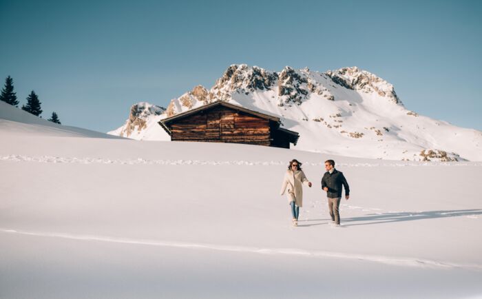 zwei Personen gehen durch den Schnee beim Winterwandern in Oberlech