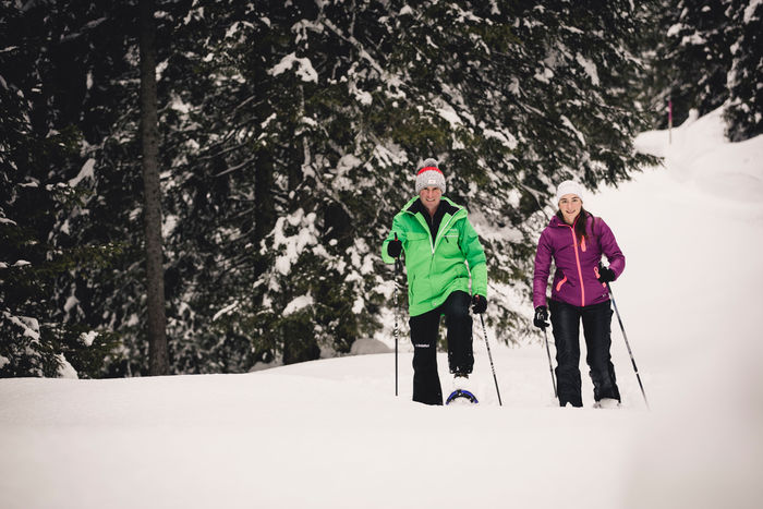 zwei Personen wandern mit ihren Schneeschuhen durch die Winterlandschaft von Lech Zürs am Arlberg