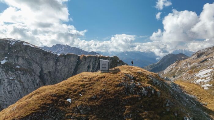 Biwak Hütte inmitten der Berge bei Sonnenschein