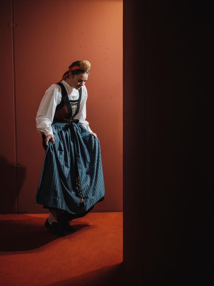 Frau in traditioneller Walser Tracht mit weißer Bluse, Mieder, Schürze und Kröneli
