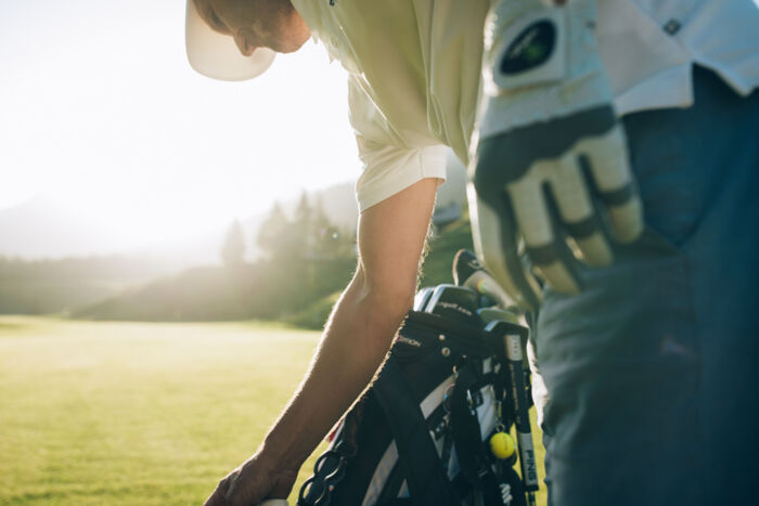 Golfer steht bei seinem Caddy am Golfplatz