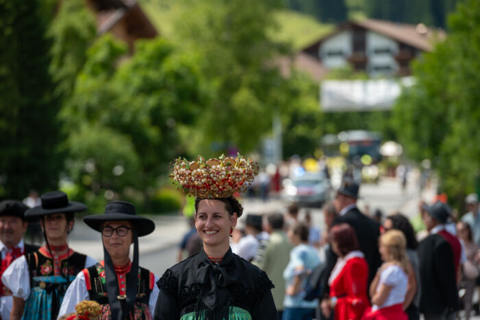 Teilnehmer:innen mit spezieller Tracht und Hüten die am Walsertreffen beim Umzug teilnehmen