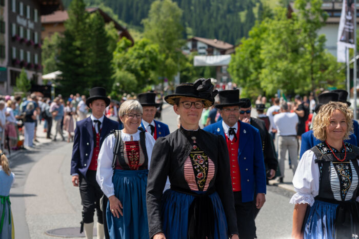 Teilnehmer:innen in traditioneller Tracht die am Umzug vom Walsertreffen teilnehmen