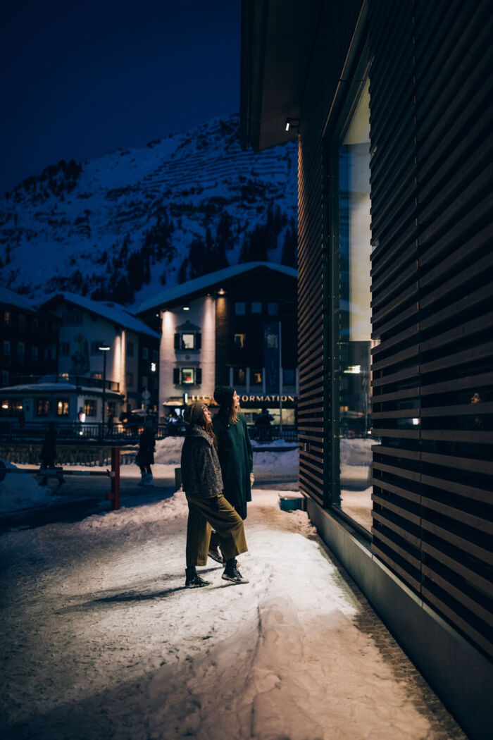 ein Paar steht vor dem Modehaus Strolz und schaut sich durch das Fenster die Verkaufsstücke an