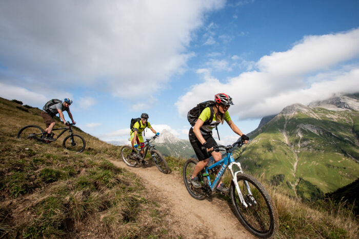 Drei Mountainbiker erkunden auf ihren Bikes die Bikewege von Lech-Zürs