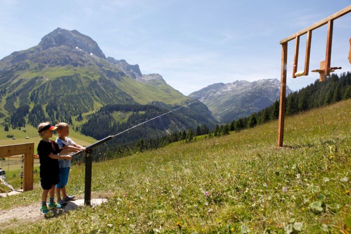 Zwei Jungs spielen am Wasserspielplatz; im Hintergrund ist das Omeshorn zu sehen