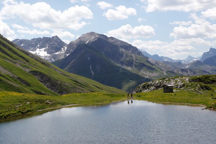 Blick über den Monzabonsee auf ein weitläufiges Bergpanorama