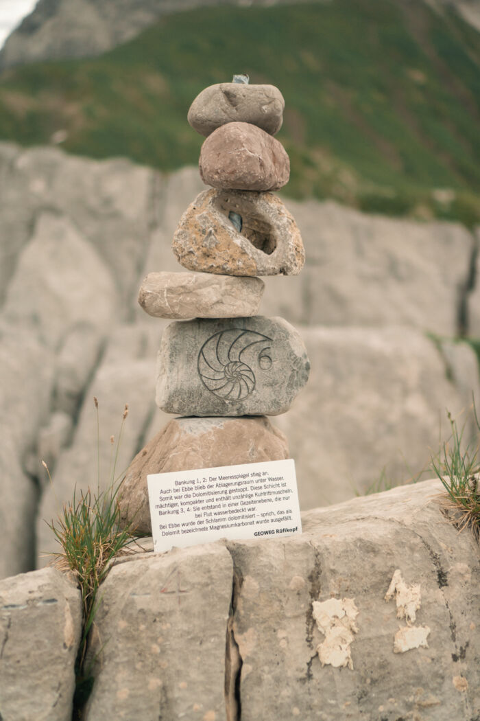 Aufeinander balancierte Steine mit dem Symbol eines Fossils.