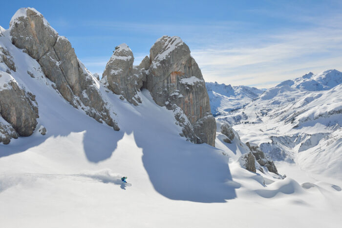 Freerider fährt zwischen kargen Felswänden die Firstline im Neuschnee