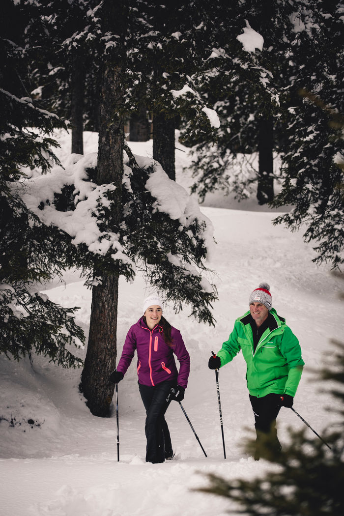 zwei Personen wandern mit ihren Schneeschuhen durch die Winterlandschaft von Lech Zürs am Arlberg