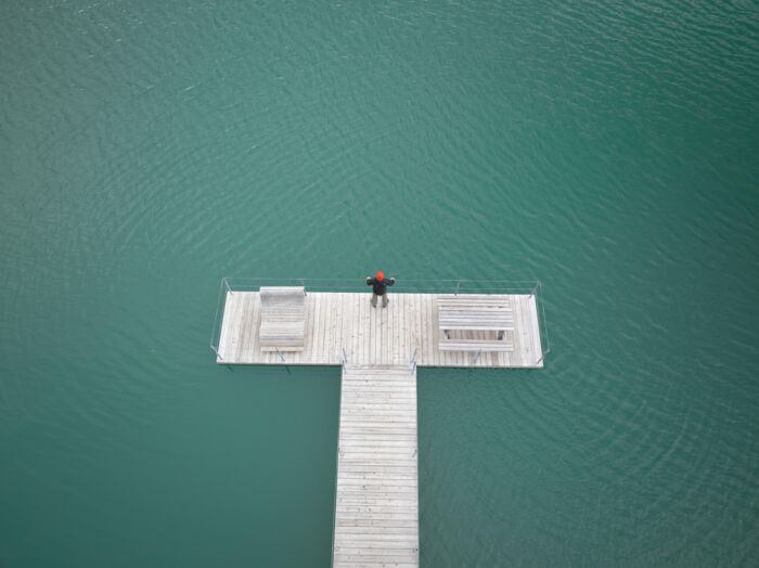 Eine Person steht am Ende des Steeges im Zürser See