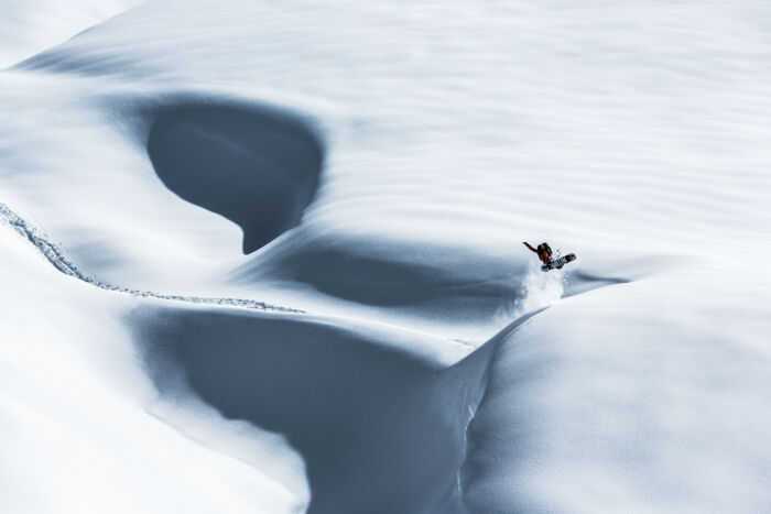 ein Snowboarder fährt durch den Tiefschnee in Vorarlberg