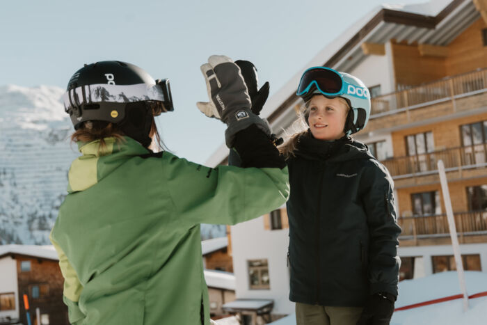Skilehrerin gibt Kind Highfive