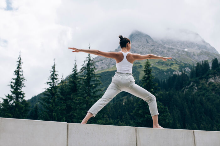 Frau praktiziert Yoga Uebing in der freien Natur