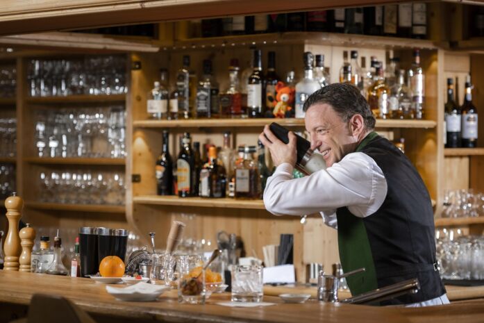 Ein Barkeeper hinter der Theke beim Cocktail shake