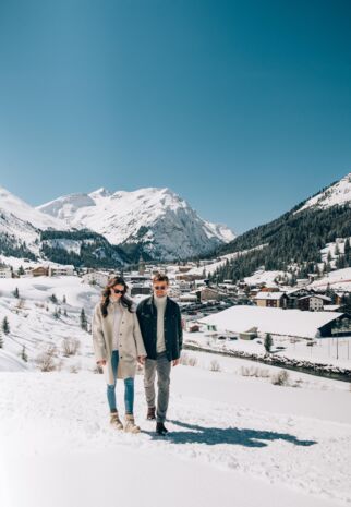 zwei Personen machen einen Winterspaziergang über den Flühenweg