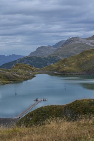 Zürsersee mit Steeg vor einem weitläufigen Bergpanorama
