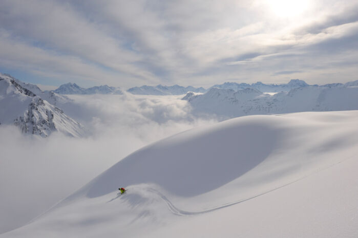 Skifahrer fährt eine Linkskurve in Pulverschnee