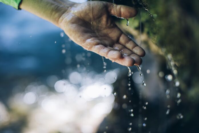 Eine Hand wird von Wassertropfen bedeckt
