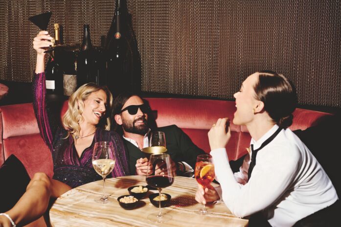 GÃ¤ste feiern in der Abendbar mit Champagner