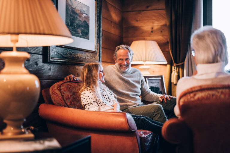 eine Familie sitzt gemeinsam auf dem Sofa im Familienurlaub in Vorarlberg