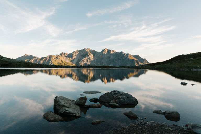Das Bergpanorama spiegelt sich in der glatten Oberfläche eines Gebirgssees 