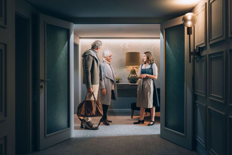 Hotelangestellte zeigt Hotelgästen ihr Hotelzimmer