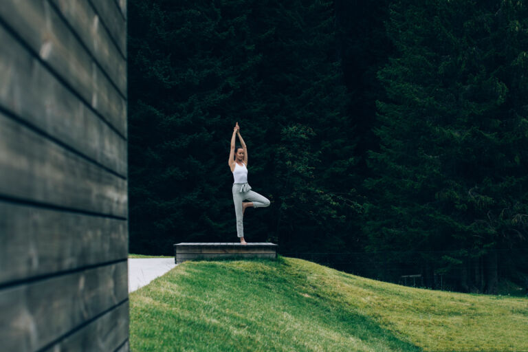 eine Frau macht inmitten der Berglandschaft Yoga