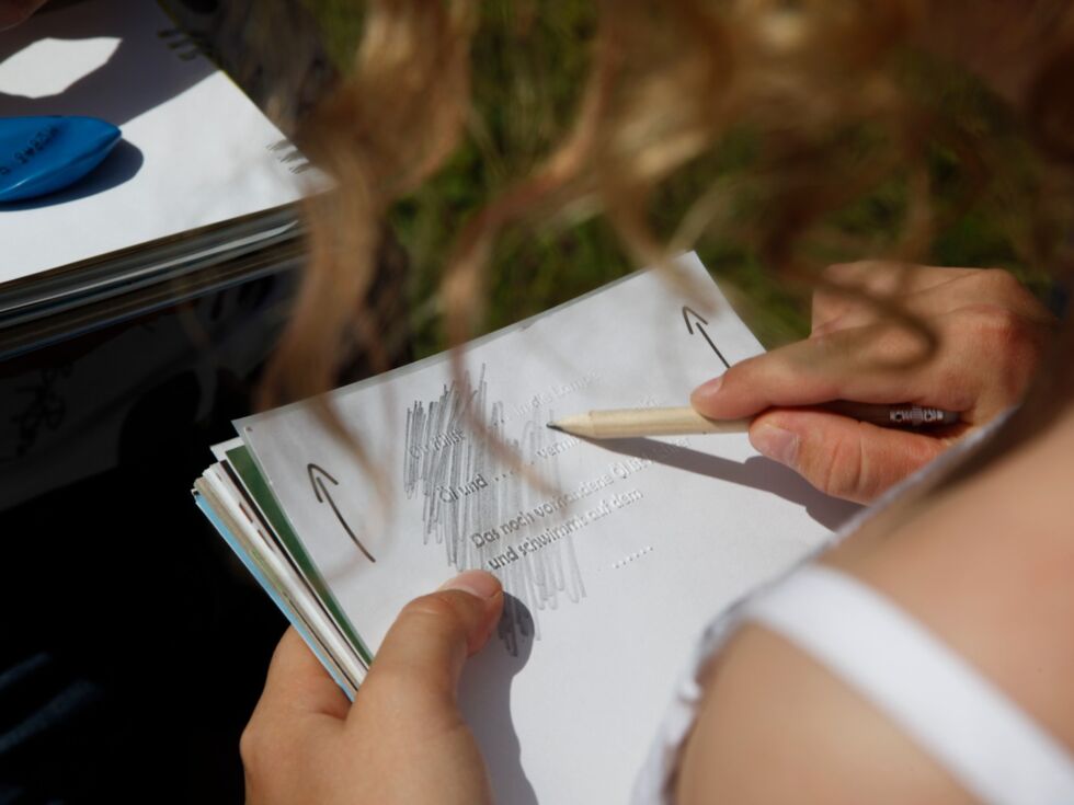 Ein Mädchen hält das Rätselbuch des Grünen Rätsel-Ring in der Hand und versucht eine Aufgabe zu lösen