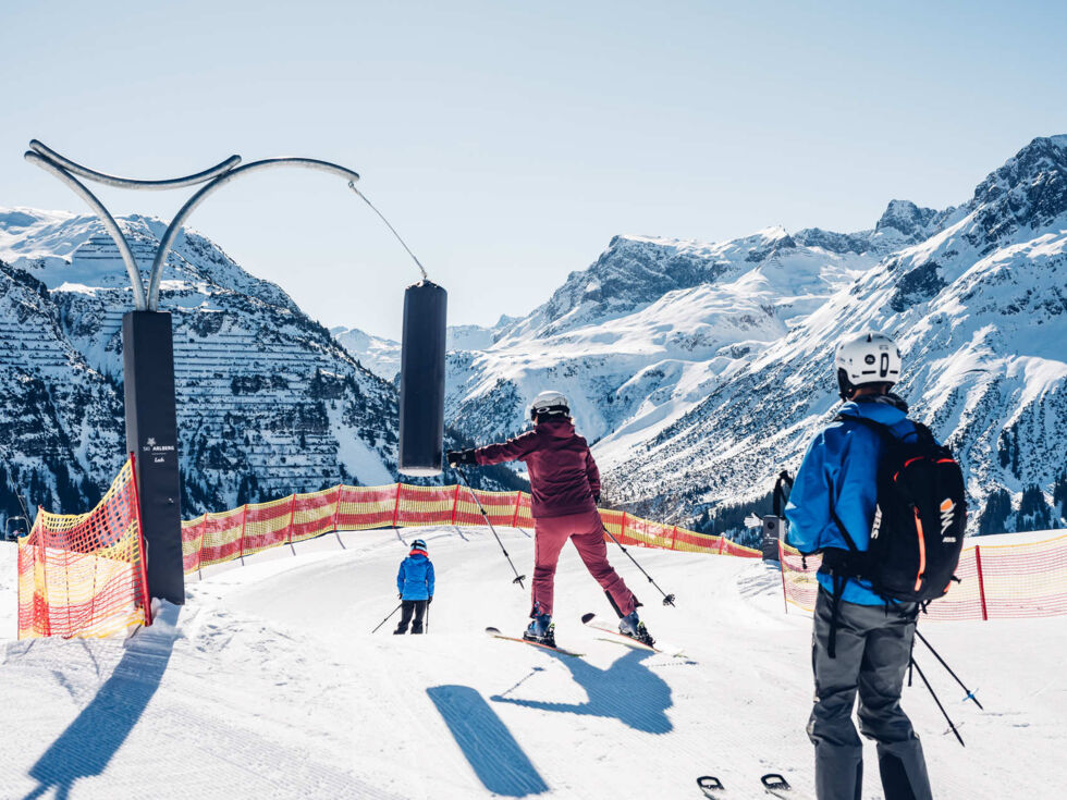 Skifahrer boxen einen hängenden Sandsack, umgeben von Bergpanorama.